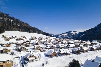 Aerial view of detached holiday homes in the snow at Alps Resorts Almdorf Hohentauern