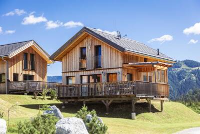 Detached holiday homes at Alps Resorts Almdorf Hohentauern, with mountains in the background