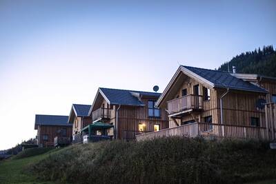 Detached wooden holiday homes on a slope at Alps Resorts Almdorf Hohentauern