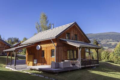 Chalet with veranda with lounge set and garden furniture at Alps Resorts Almdorf Stadl