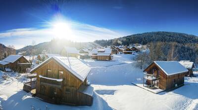 Detached wooden chalets in the snow at Alps Resorts Almdorf Stadl