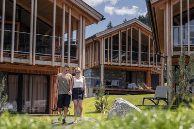 Man and woman walking between holiday homes at Alps Resorts Bergresort Hauser Kaibling