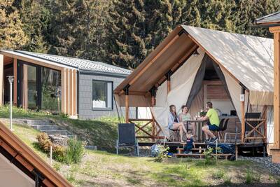 Family on the terrace of a glamping tent at Alps Resorts Chalets and Glamping Nassfeld