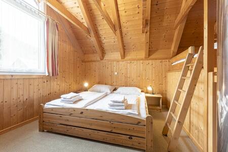 Bedroom with double bed and bunk bed in a holiday home at FerienPark Kreischberg