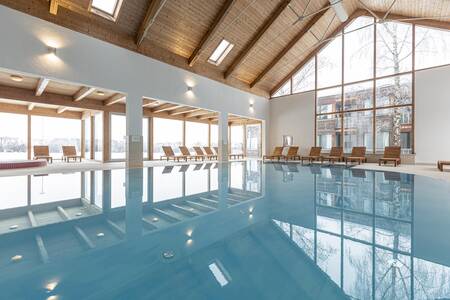 The indoor pool with sun loungers at Alps Resorts FerienPark Kreischberg