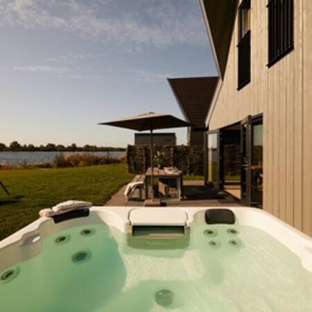 Whirlpool and dining table in the garden of a holiday home at the Dutchen Baayvillas holiday park